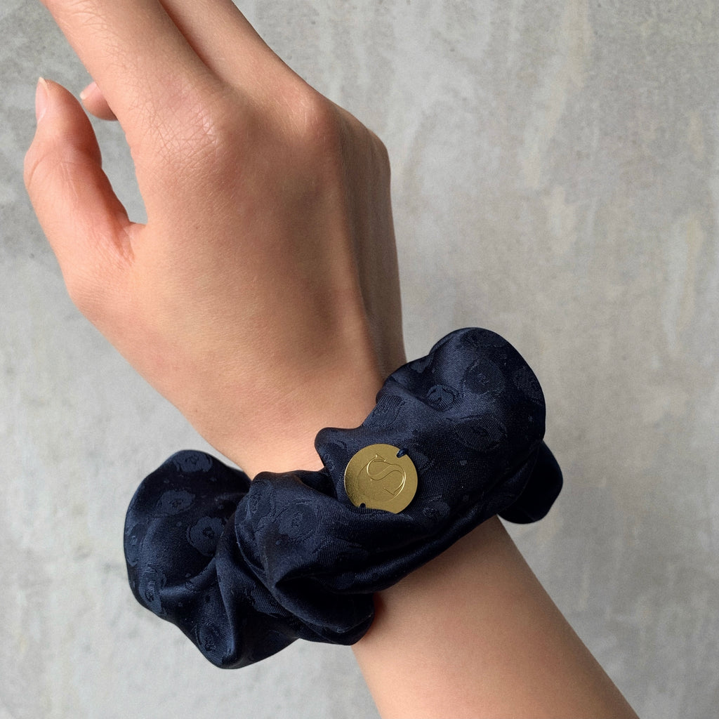 Sapphire - hand model standard size scrunchie in a inky blue silk satin jacquard.