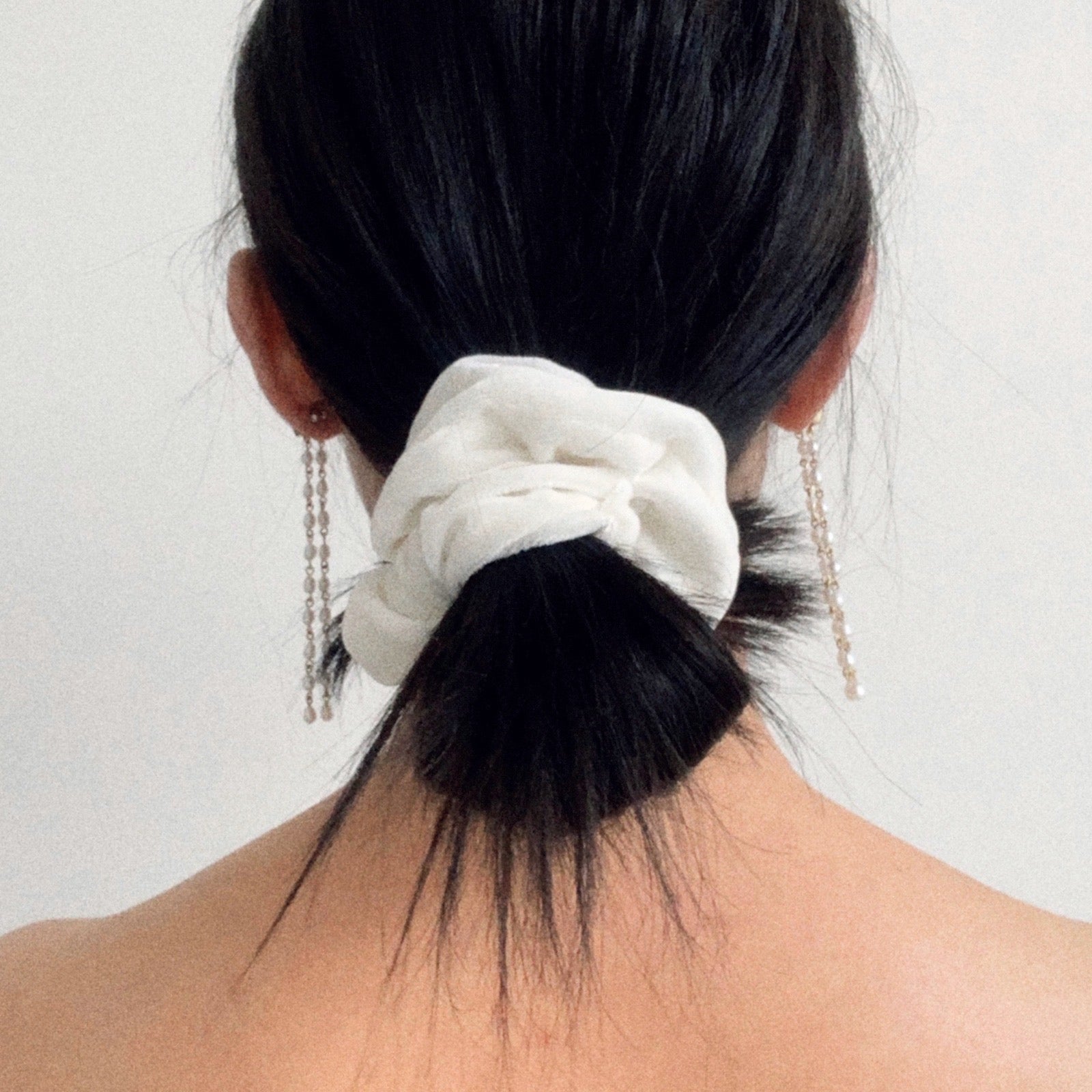 Pearl - model wearing a white silk velvet scrunchie in the standard size.