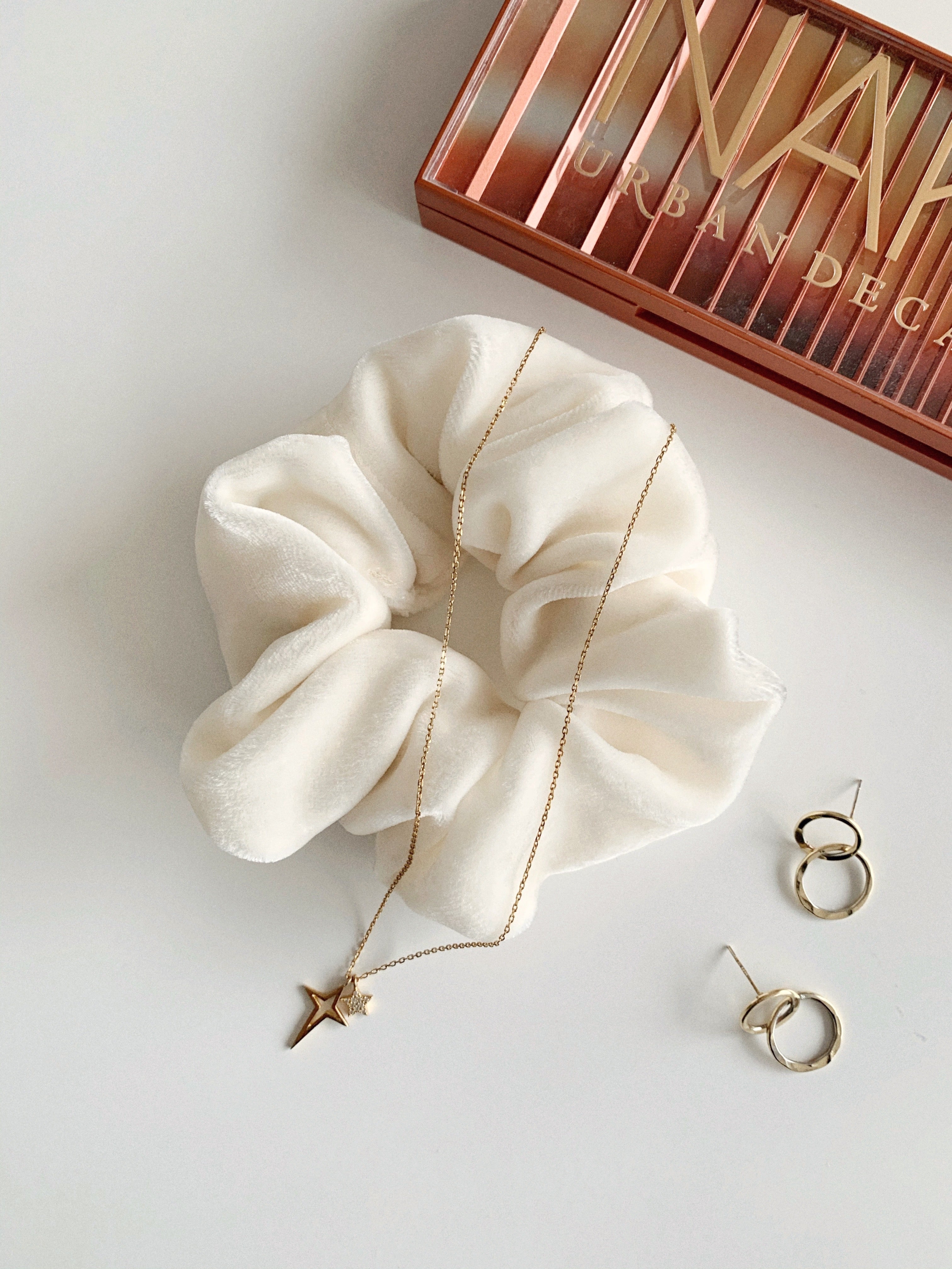 Pearl - flat lay of a white silk velvet scrunchie in the standard size.