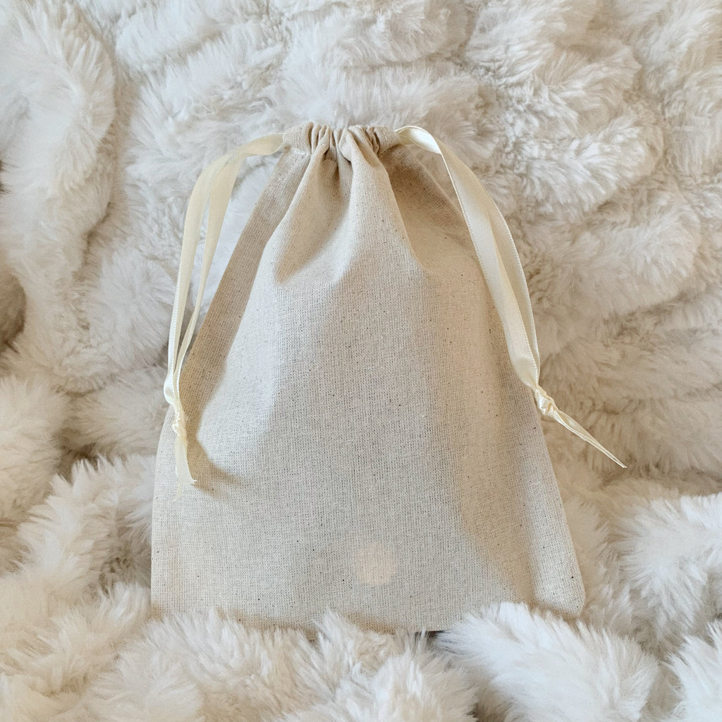 Photo of a luxury gift bag featuring an ivory satin double drawstring.