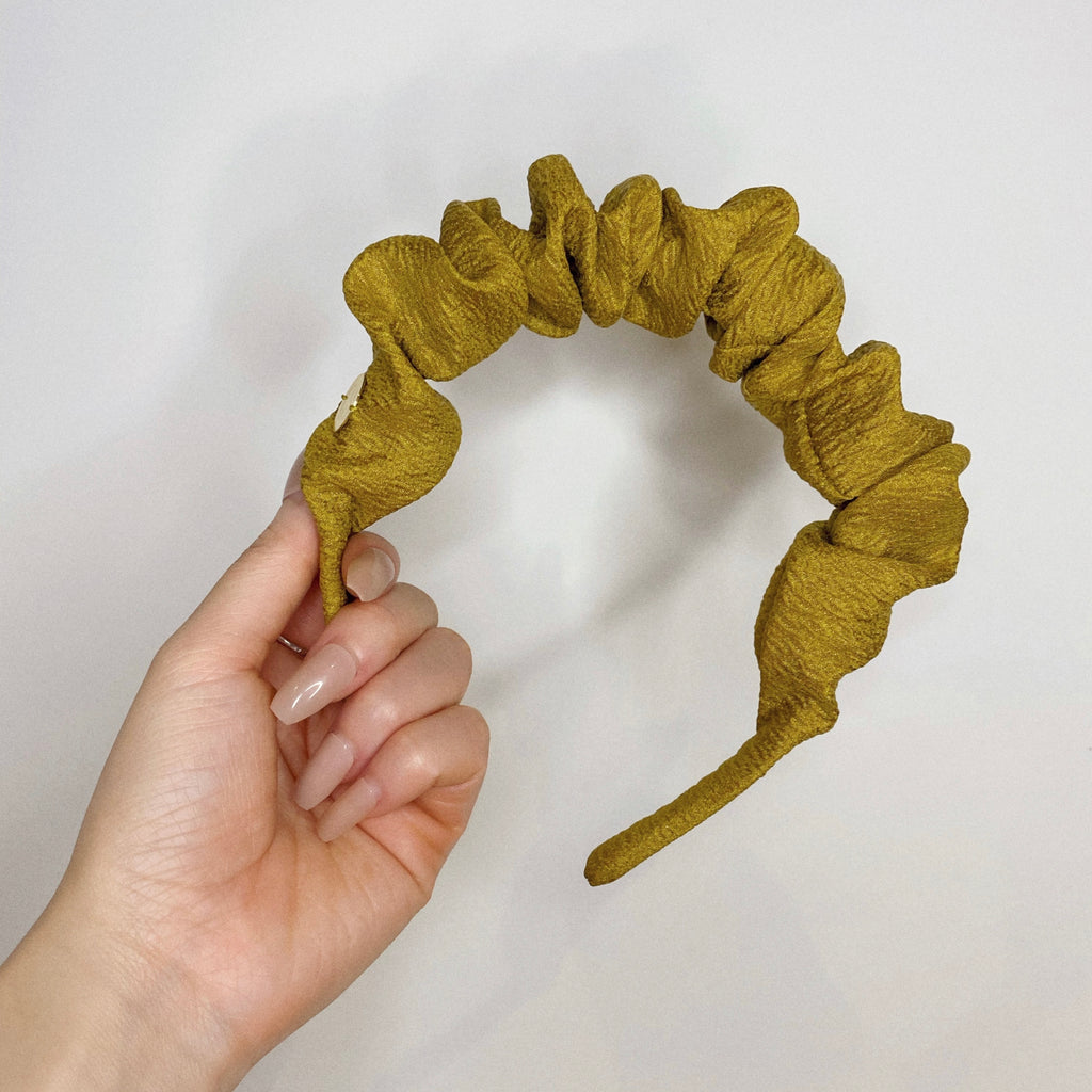 Model's hand holding a scrunchie headband in Chartreuse.