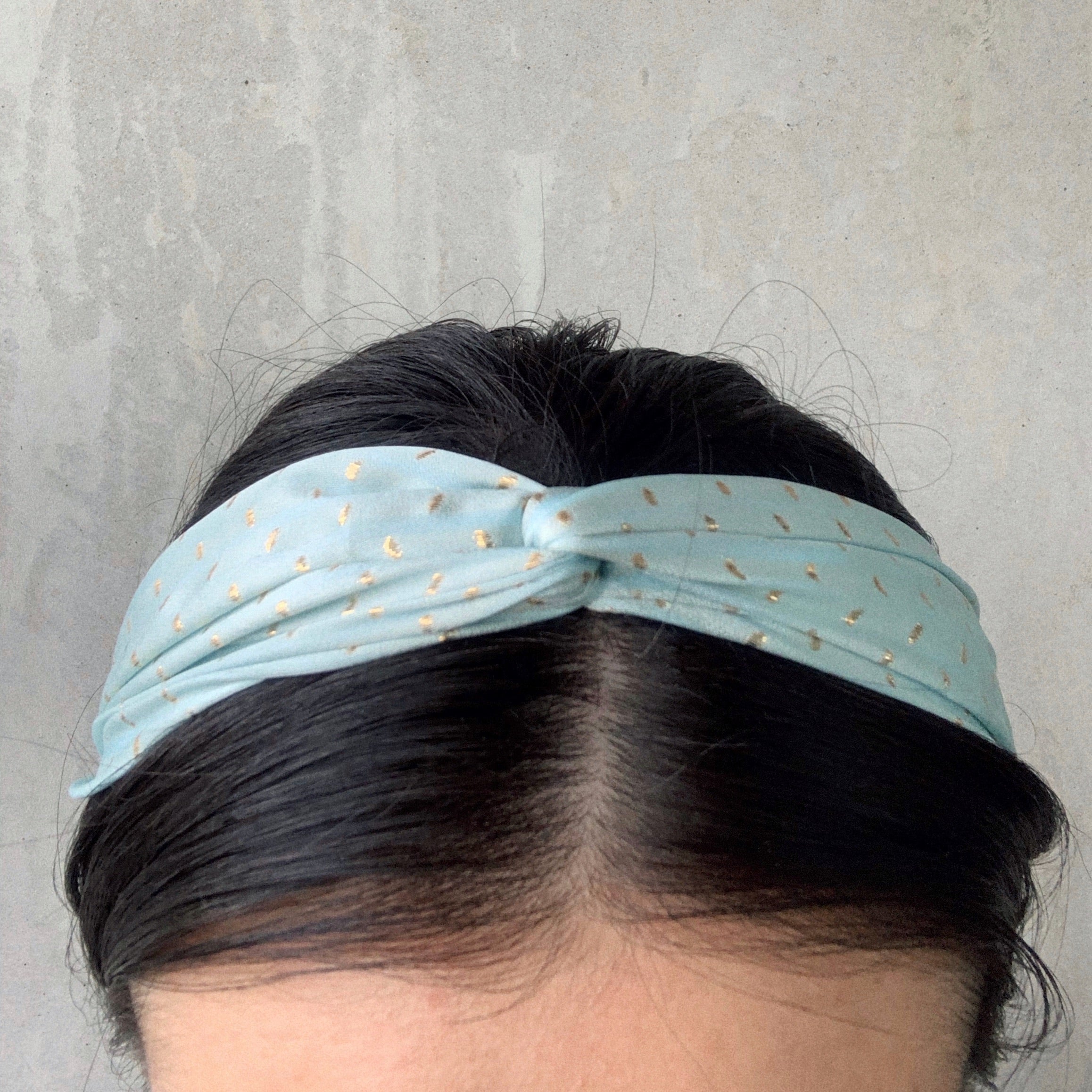 Baby Blue - model wearing twisted headbands in a light blue silk stain with gold lurex spots.