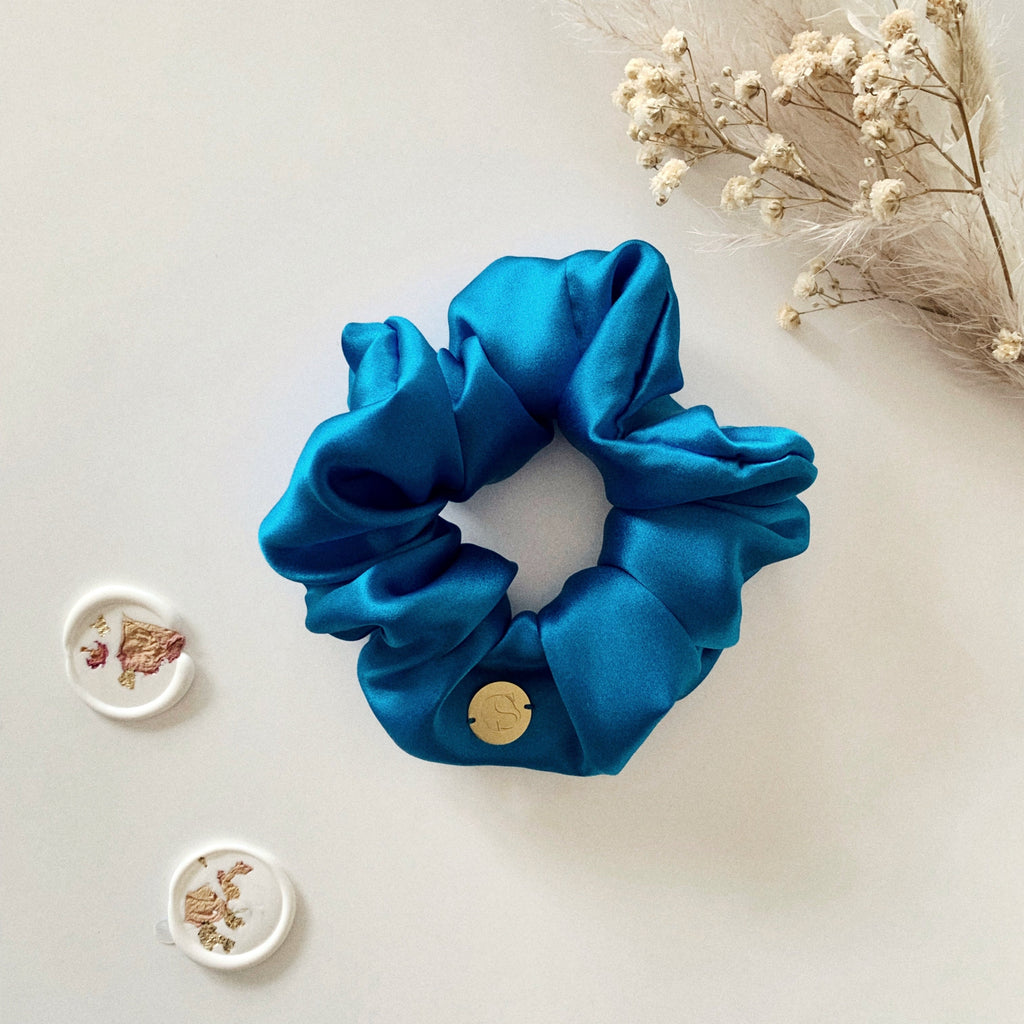 Flat lay of a blue silk scrunchie.