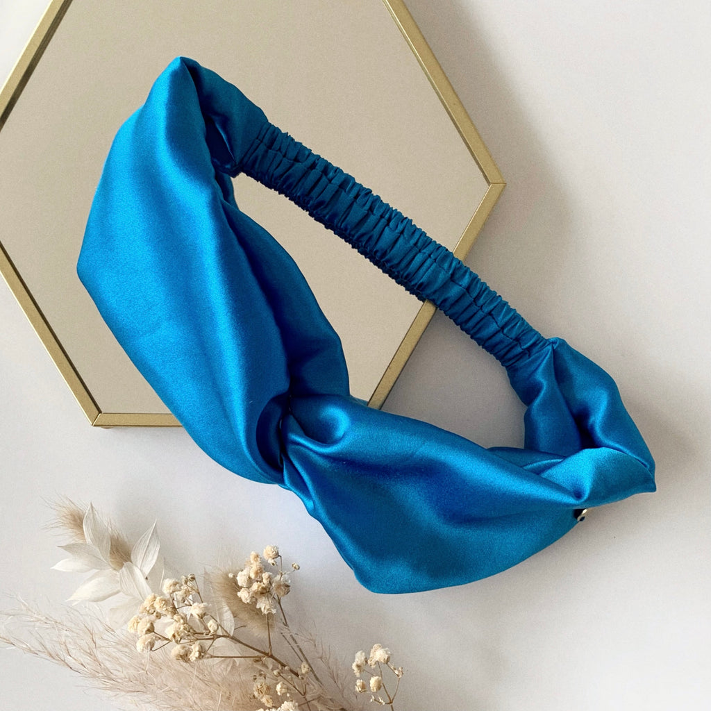 Flat lay of a twisted headband in blue.