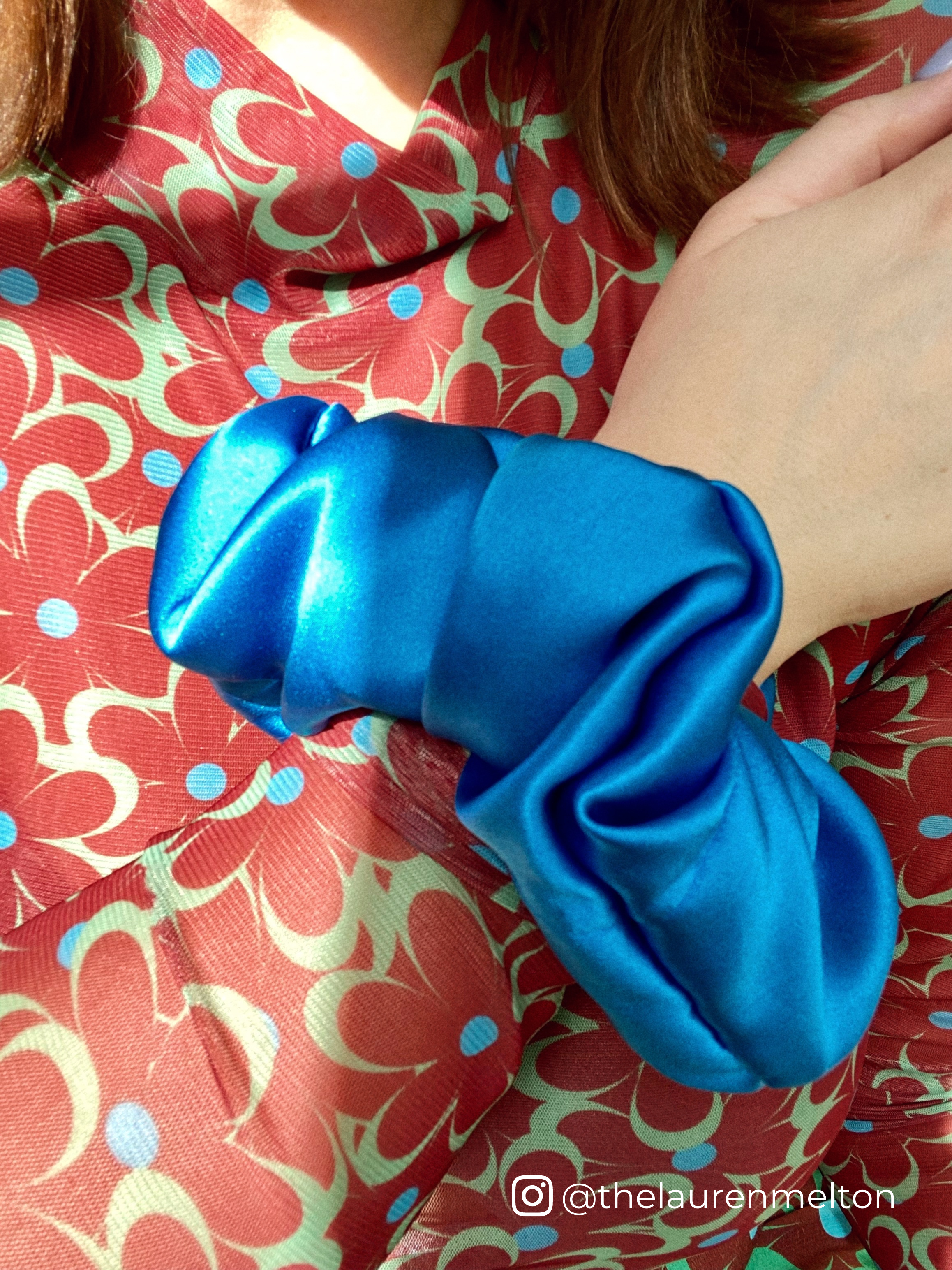 Influencer Lauren Melton wears blue silk satin scrunchie on her wrist.